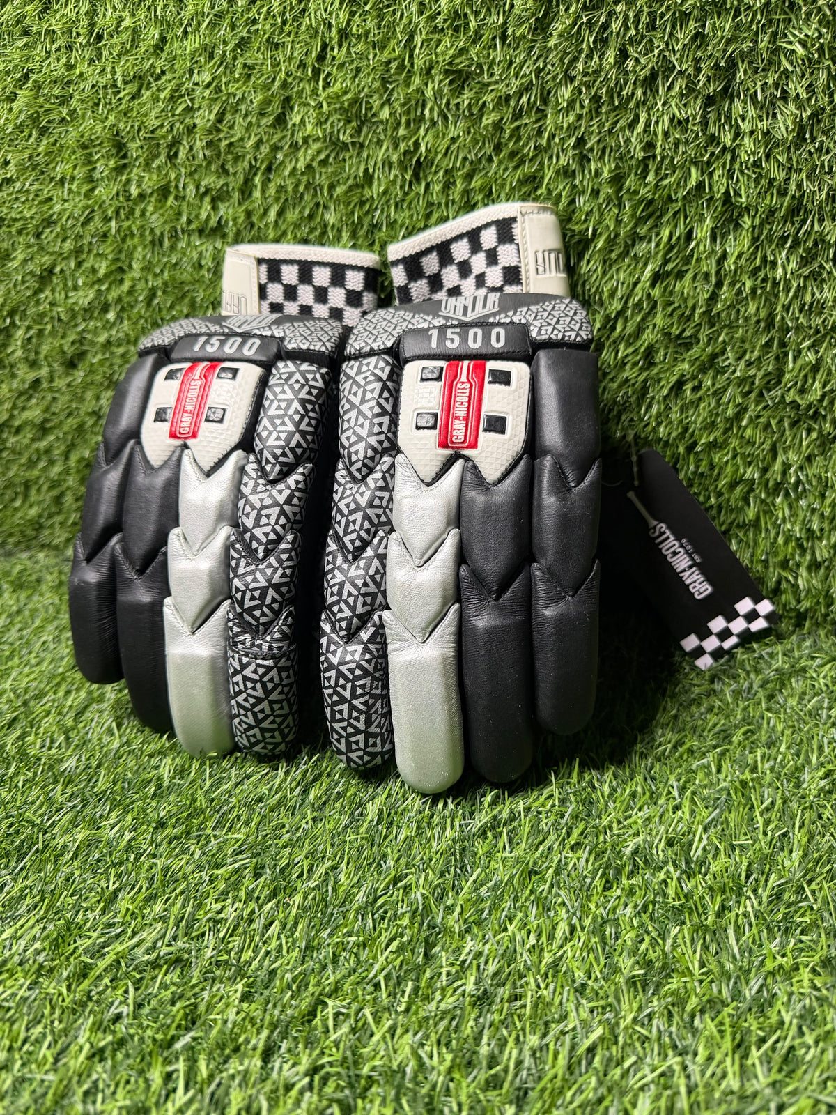 Gray-Nicolls Vapour black and silver cricket batting gloves on green artificial turf