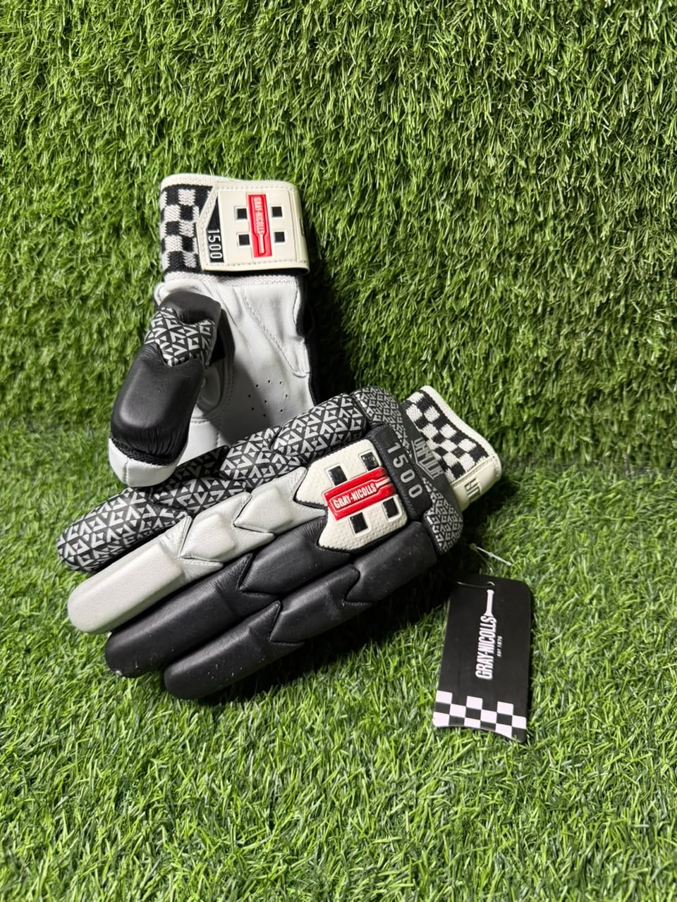 Gray-Nicolls Vapour black and silver cricket batting gloves on green artificial turf
